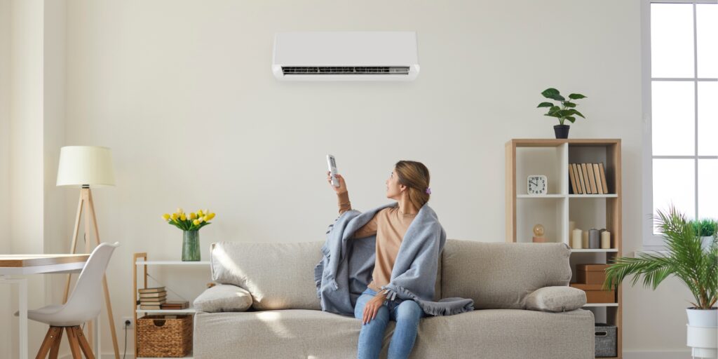 woman on a couch with AC remote