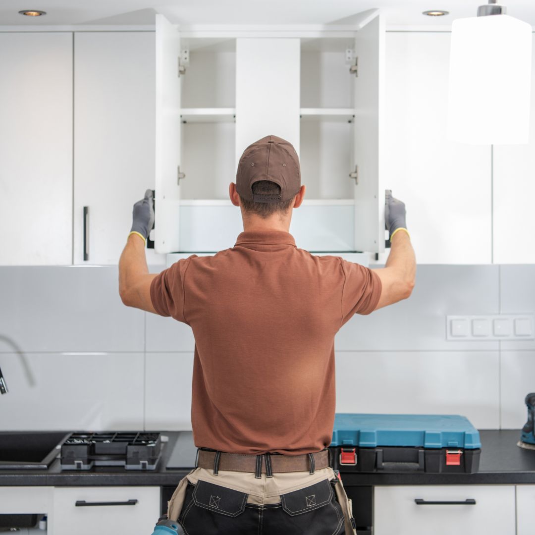 Man opening up cabinets in kitchen